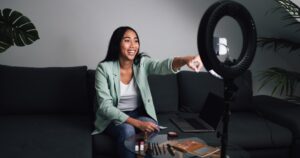 Influenceuse enregistrant une vidéo de maquillage avec ring light illustrant quelles sont les sources de revenus des influenceurs du web